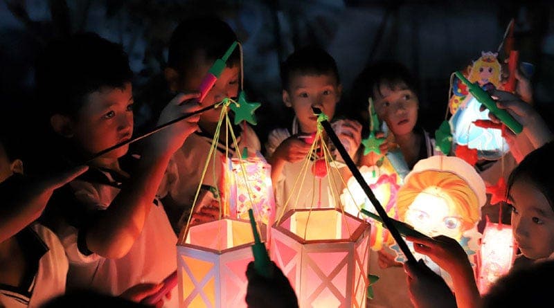 Những đứa trẻ đang đốt lồng đèn vui chơi sum vầy đêm Trung Thu